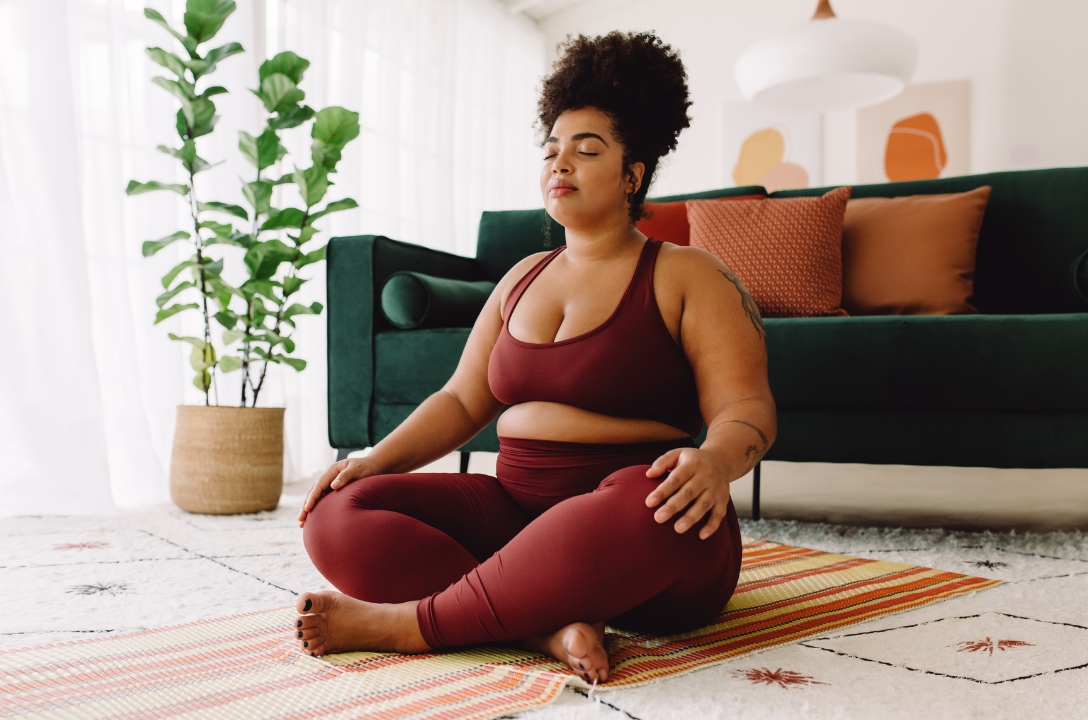 woman sitting on a yoga mat meditating