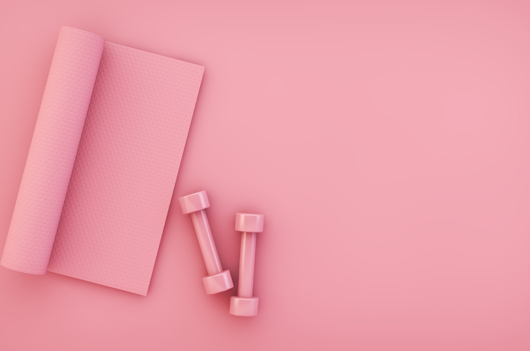 pink yoga matt and pink dumbells on a pink background