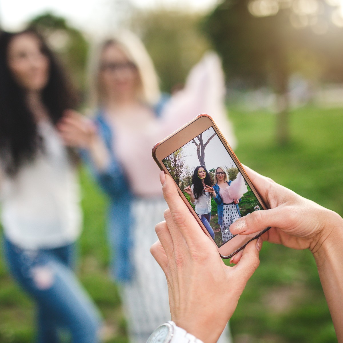 2 friends having their photo taken on an phone